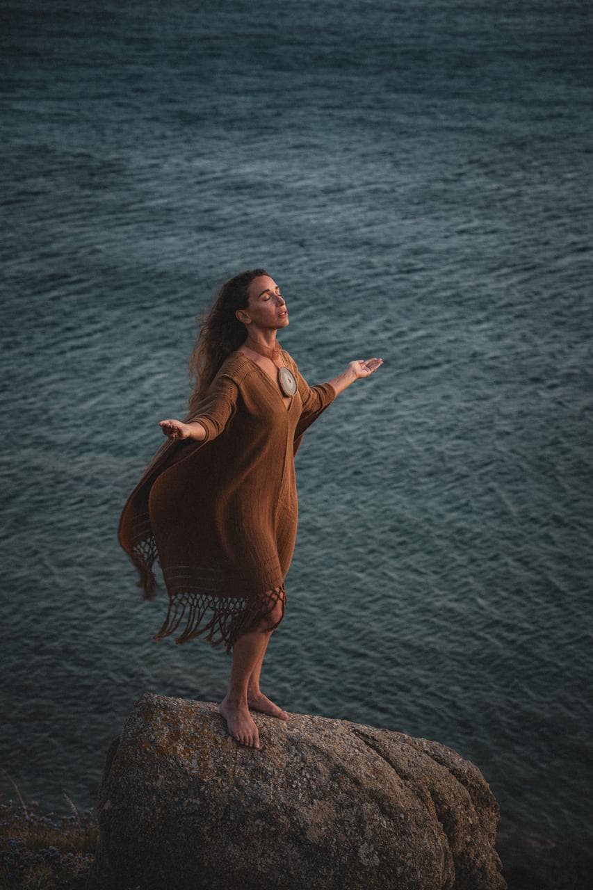 Jennifer at the shoreline, arms open to the water