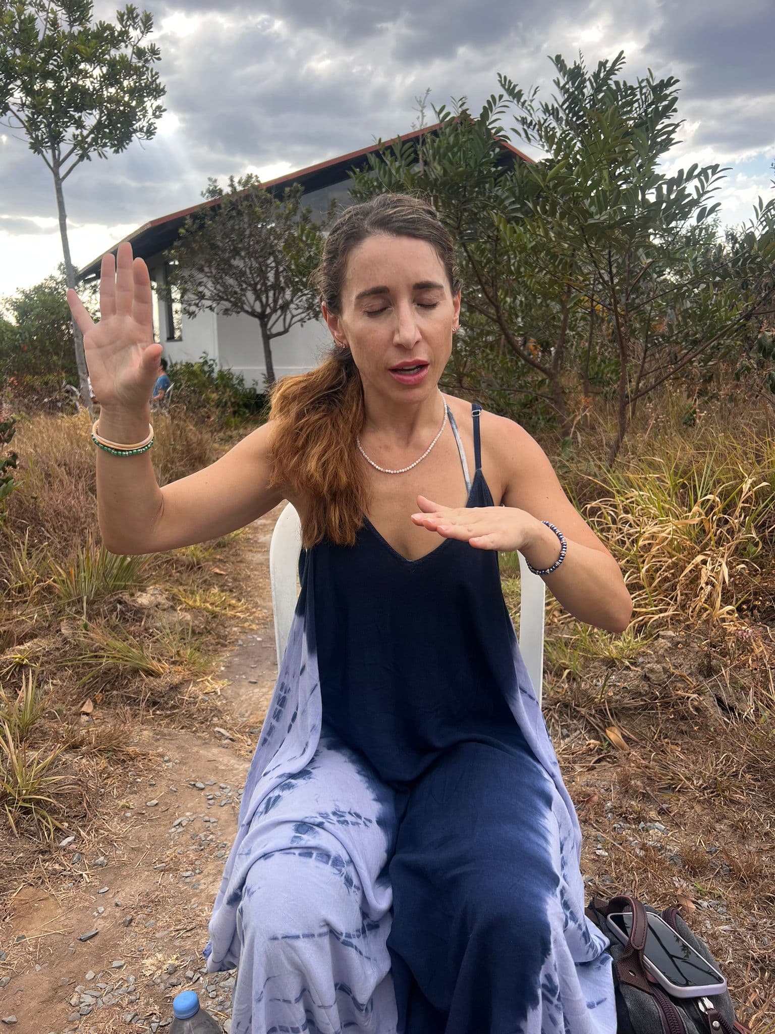 Jennifer teaching outdoors, hands raised